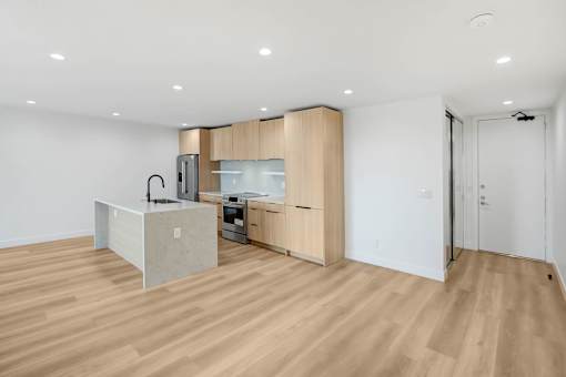 A kitchen with a white counter and wooden floors.