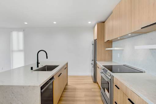 A modern kitchen with wooden cabinets and stainless steel appliances.
