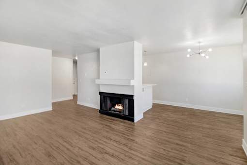 A living room with a fireplace and wood flooring.