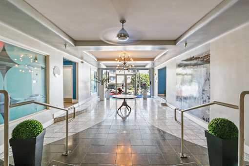 A long hallway with a table and chairs in the middle.
