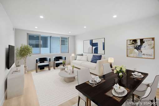 A modern living room with a dining table set for two.