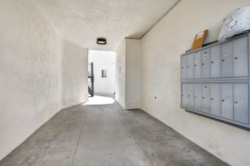 a concrete hallway with a gray cabinet on the left and a white wall on the right