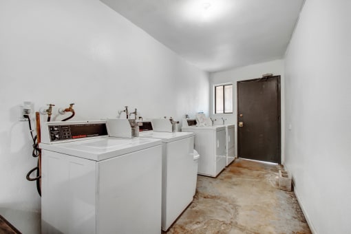 a laundry room with white appliances and white walls