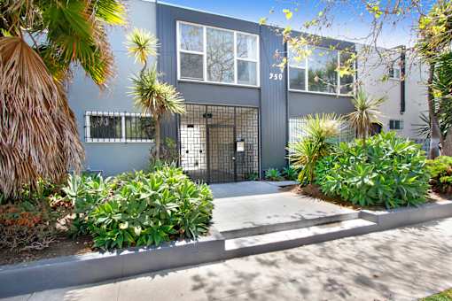 A modern house with a grey exterior and a black gate.