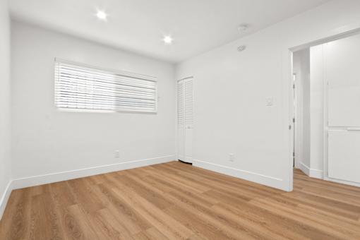 A room with wooden flooring and white walls.