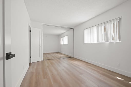 A room with a wooden floor and a white door.