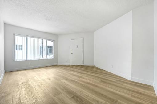 A room with wooden flooring and a white door.