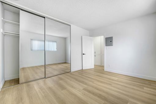 A room with a sliding door and a wooden floor.