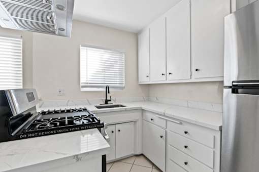 A kitchen with white cabinets and a black stove top.