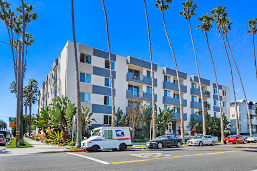 A blue and white building with a USPS van parked in front.
