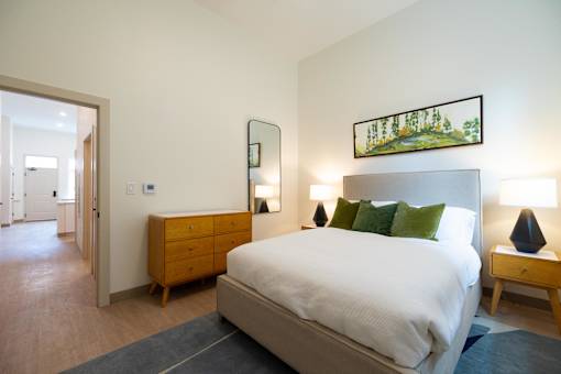 A bedroom with a bed, nightstand, and lamp.