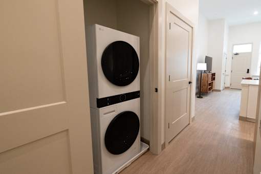 A washing machine is built into a wall in a room.