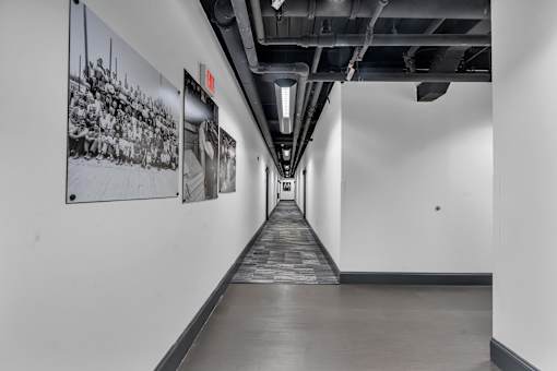 A long hallway with a black and white picture on the wall.