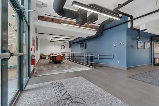 A room with a blue wall and a grey carpet with the word GRANTE on it.
