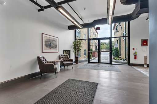 A room with a grey floor and a fire extinguisher on the wall.