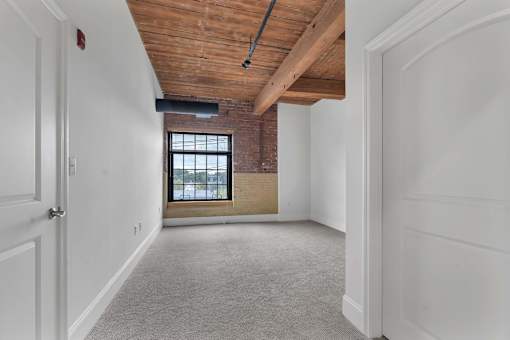 A room with a wooden ceiling and a window.