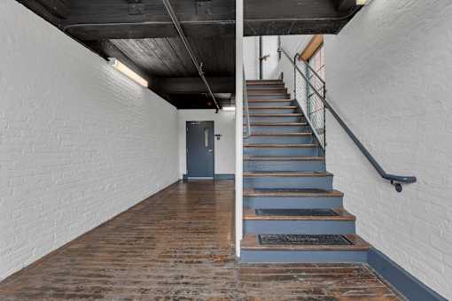 A staircase with a metal railing and wooden steps.