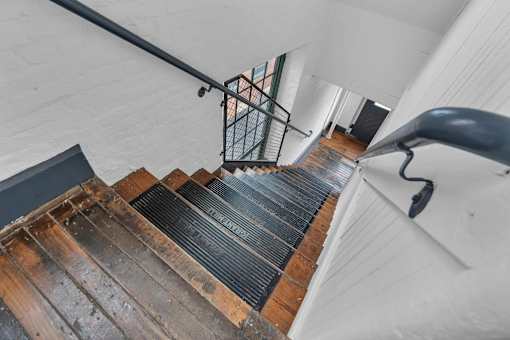 A staircase with a metal railing and wooden steps.