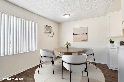 A dining room nicely lit by a large window.