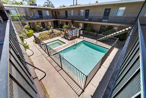 A pool in a courtyard surrounded by a fence.