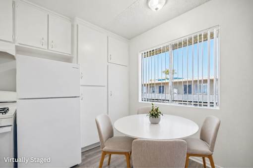 A kitchen with a table and chairs in front of a window.