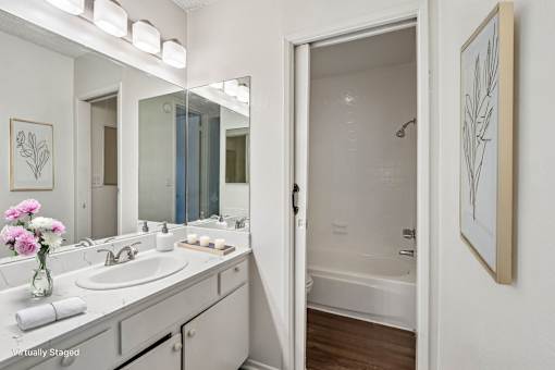 A bathroom with a white sink and a white tub.