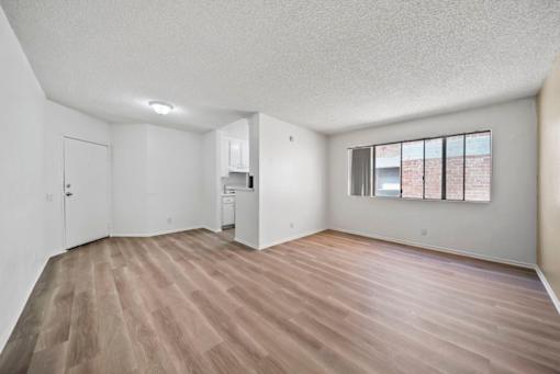 A room with wooden flooring and white walls.
