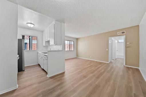 A kitchen with white cabinets and a refrigerator.