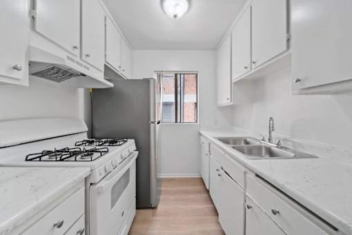 A kitchen with white appliances and cabinets.