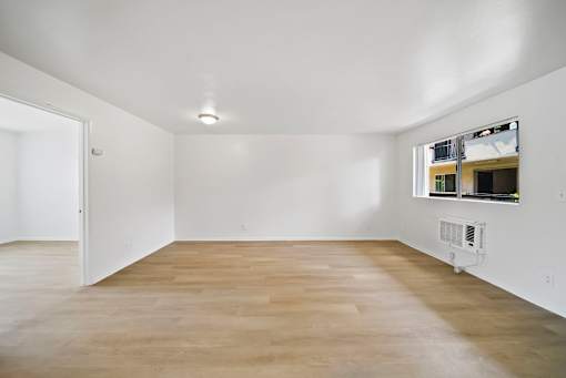 A room with a white ceiling and a window with a view of a building.