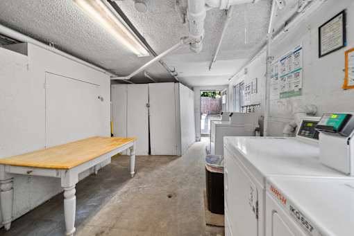 A white industrial room with a table and a white machine.
