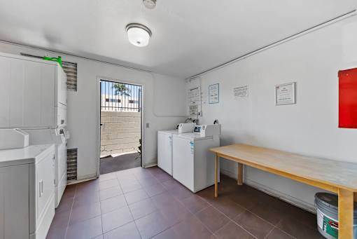 A kitchen area with a washing machine and a dining table.