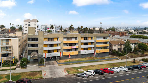 A parking lot with cars and a building in the background.