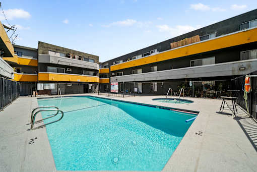 A swimming pool in a courtyard surrounded by buildings.
