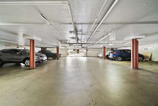 A parking garage with several cars parked in it.