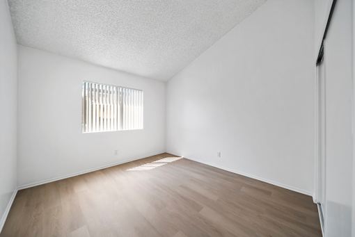 A room with a window and wooden flooring.