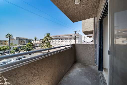 A balcony with a view of a street and buildings.