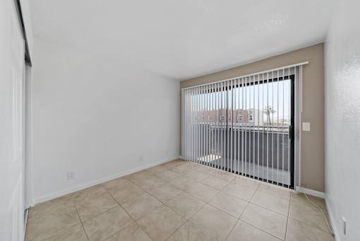 A room with a sliding door and a balcony.