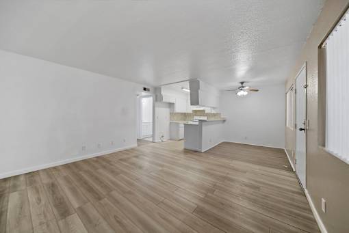 A room with wooden flooring and a ceiling fan.