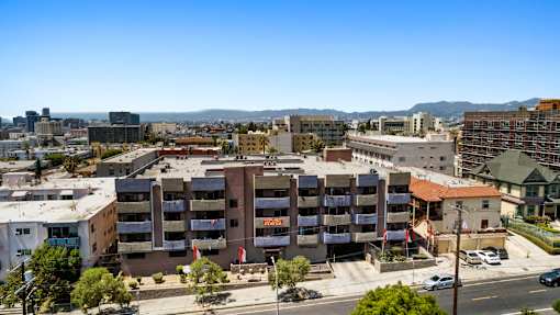A large apartment complex is surrounded by buildings and trees.