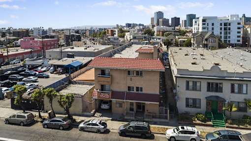 A parking lot with cars and buildings in the background.