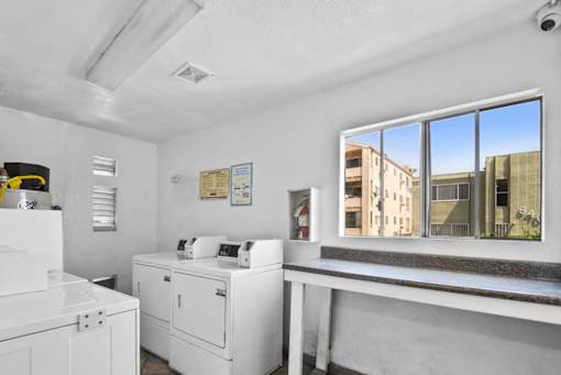 A white room with a large window showing a view of a building outside.