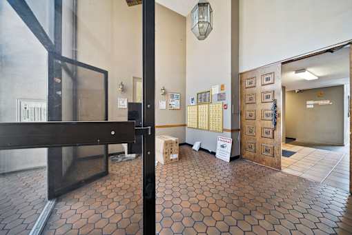 A hallway with a tile floor and a white sign on the wall.