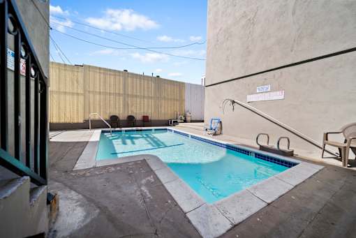 A small pool with a diving board and a sign that says "SWIMMING POOL".