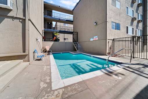 A small pool in a courtyard surrounded by buildings.
