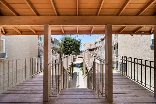 A wooden staircase with metal railings leads up to a building.