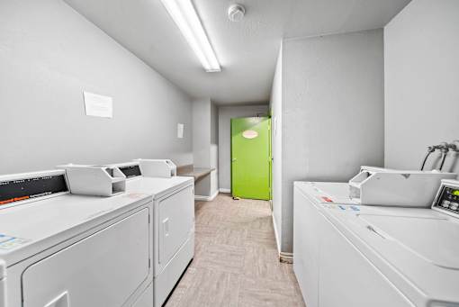 A row of white copiers in a clean, empty room.