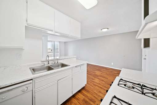 A kitchen with white cabinets and a white counter top.
