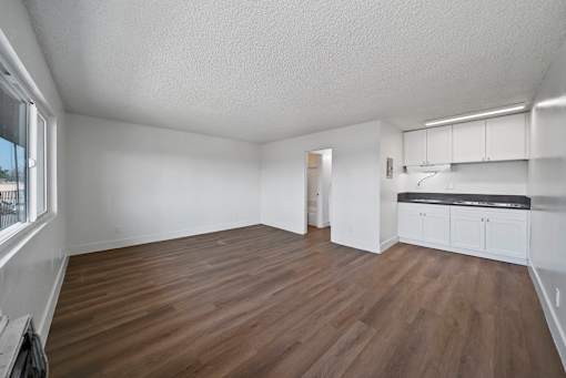 A room with wooden flooring and white walls.