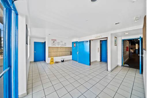 A hallway with blue doors and white walls.